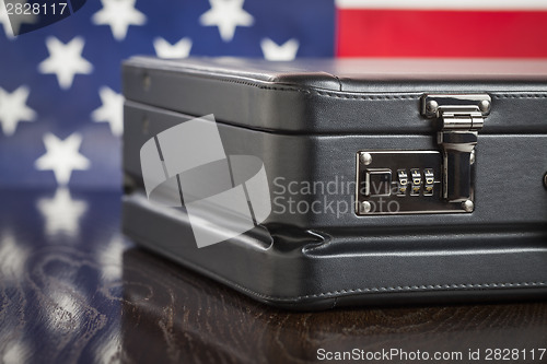 Image of Leather Briefcase Resting on Table with American Flag Behind