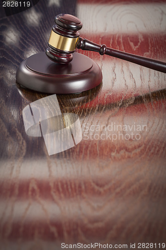 Image of Wooden Gavel Resting on Flag Reflecting Table