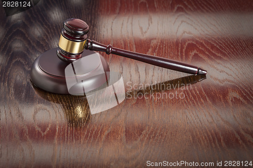 Image of Wooden Gavel Resting on Flag Reflecting Table