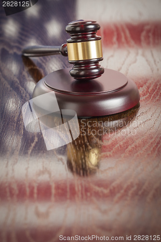 Image of Wooden Gavel Resting on Flag Reflecting Table