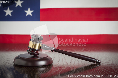 Image of Wooden Gavel Resting on Flag Reflecting Table