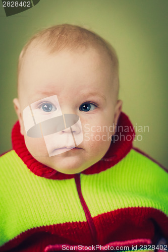 Image of Portrait Of Sad Baby Boy On Green Background