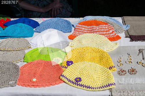 Image of crocheted colorful baby hat lying on stall fair 