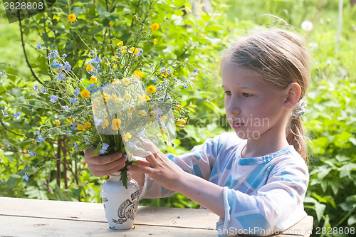 Image of little girl making bunch of flowers
