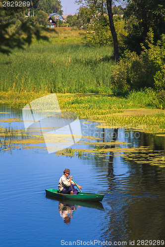 Image of Man Fishing Out Of A Row Boat