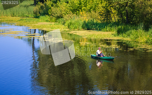 Image of Man Fishing Out Of A Row Boat