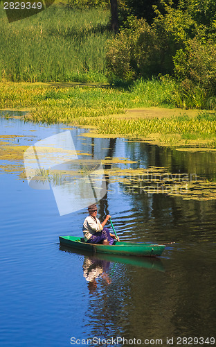 Image of Man Fishing Out Of A Row Boat