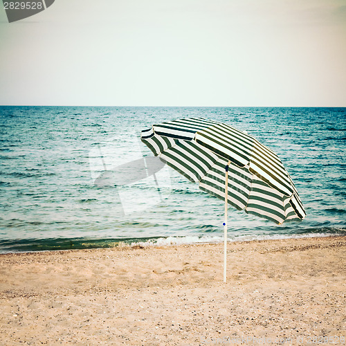 Image of Striped umbrella on sandy beach