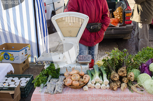 Image of vegetable lying on market stall near retro scales 