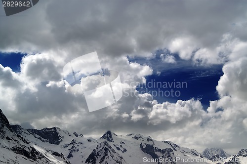 Image of Snowy mountains in beautiful clouds