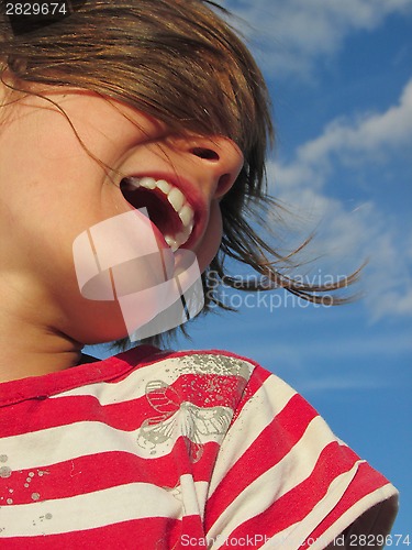 Image of happy laughing child against blue sky