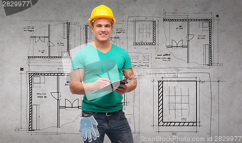 Image of smiling man in helmet with clipboard