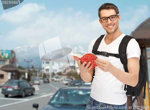 Image of travelling student with backpack and book