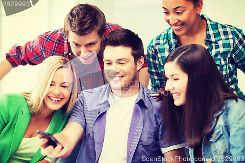 Image of students looking into smartphone at school