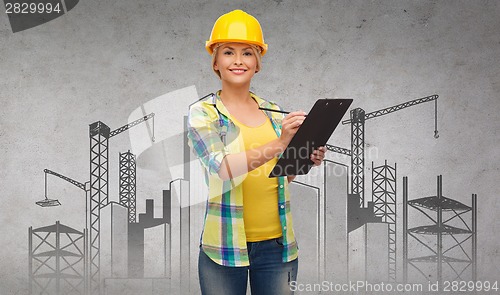 Image of smiling woman in helmet with clipboard