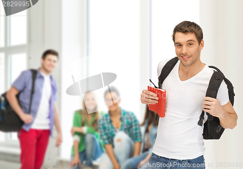 Image of travelling student with backpack and book