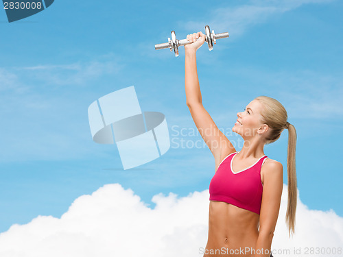 Image of smiling woman with heavy steel dumbbell