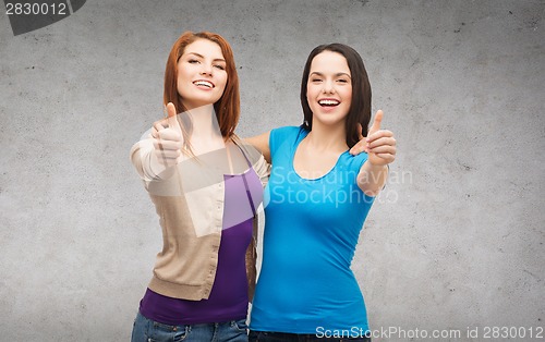 Image of two smiling girls showing thumbs up