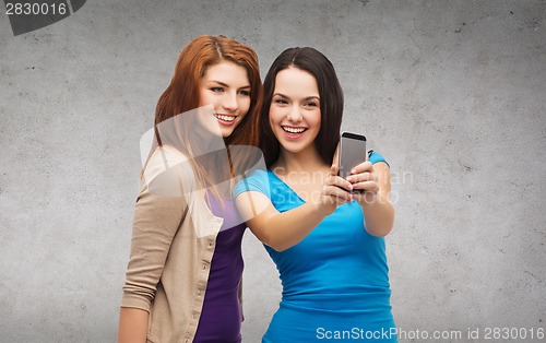 Image of two smiling teenagers with smartphone