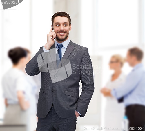 Image of young smiling businessman with smartphone
