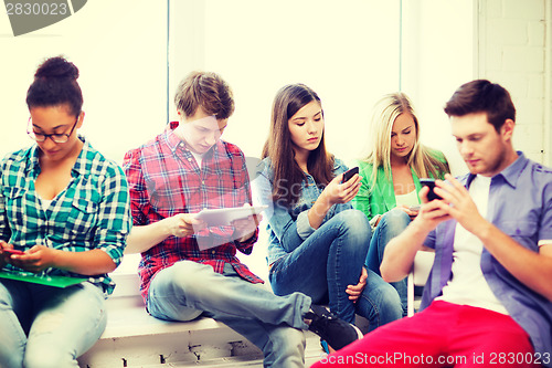 Image of students looking into devices at school