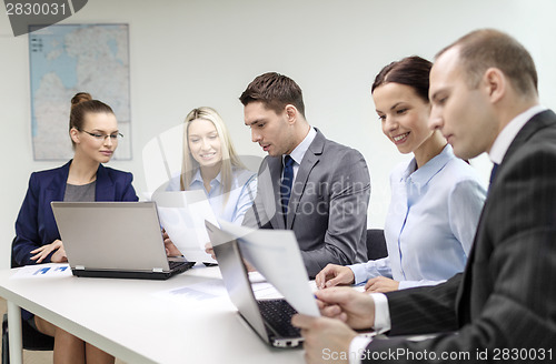 Image of business team with laptop having discussion