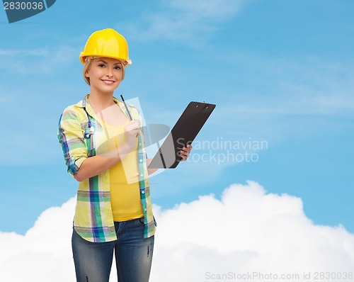 Image of smiling woman in helmet with clipboard