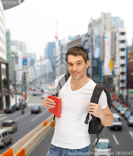 Image of travelling student with backpack and book