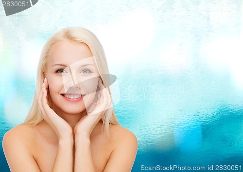 Image of face of beautiful woman touching her face skin