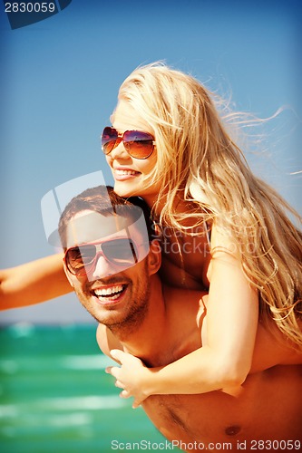 Image of happy couple in sunglasses on the beach