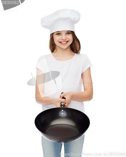 Image of smiling girl in cook hat giving frying pan