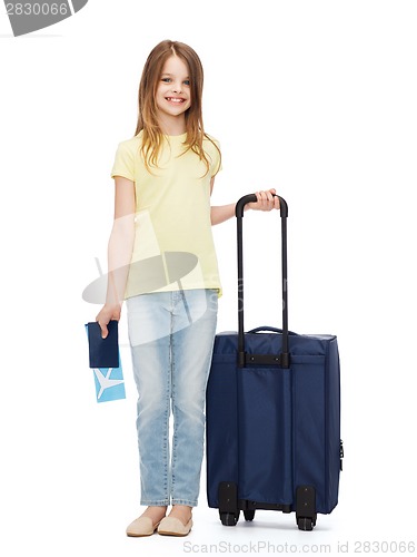 Image of smiling girl with suitcase, ticket and passport