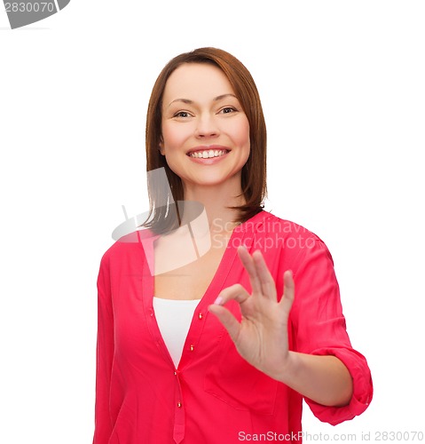 Image of woman in casual clothes showing ok gesture