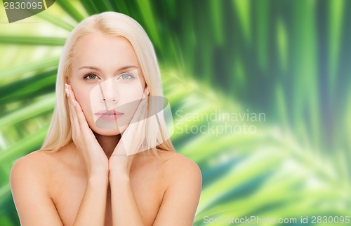 Image of face of beautiful woman touching her face skin