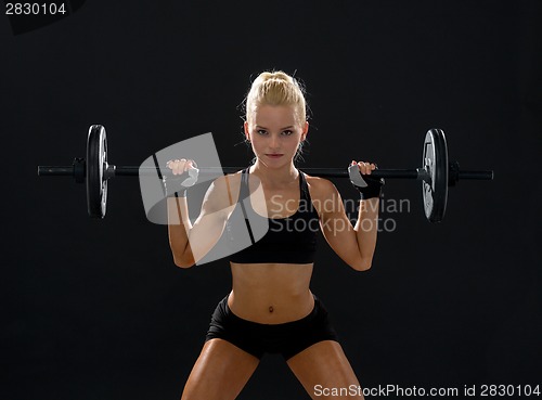 Image of sporty woman exercising with barbell