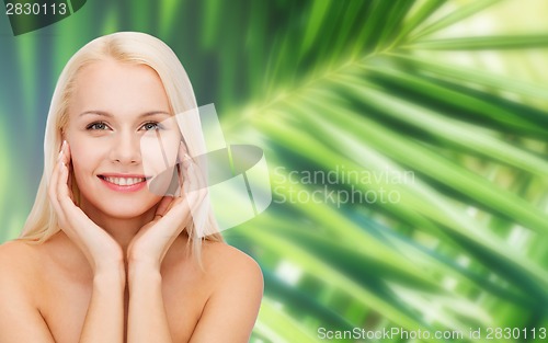 Image of face of beautiful woman touching her face skin