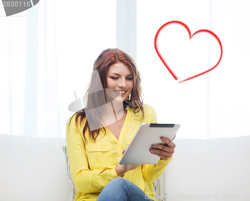 Image of smiling woman with tablet pc computer at home