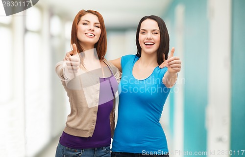 Image of two smiling girls showing thumbs up