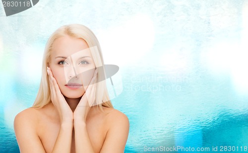 Image of face of beautiful woman touching her face skin