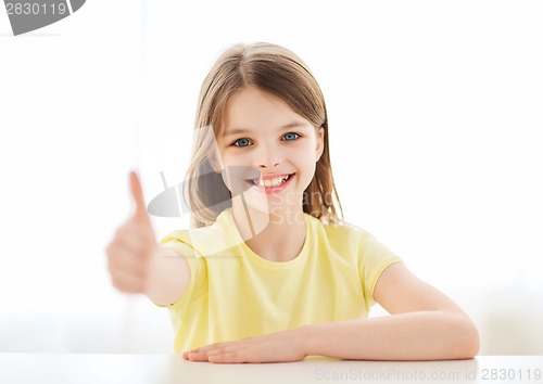 Image of beautiful little girl at home showing thumbs up
