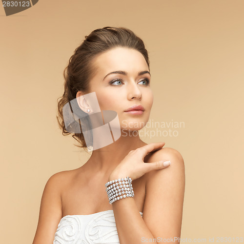 Image of woman with pearl earrings and bracelet