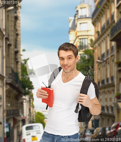 Image of travelling student with backpack and book