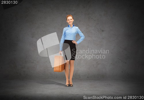 Image of smiling businesswoman with suitcase