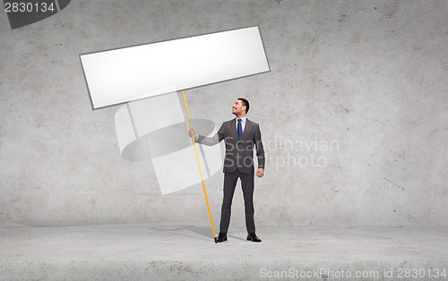 Image of smiling businessman holding white blank board