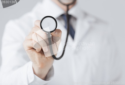Image of doctor hand with stethoscope listening something