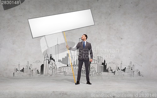 Image of smiling businessman holding white blank board