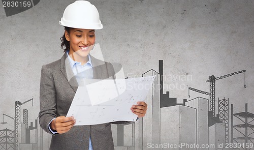 Image of businesswoman in white helmet with blueprint