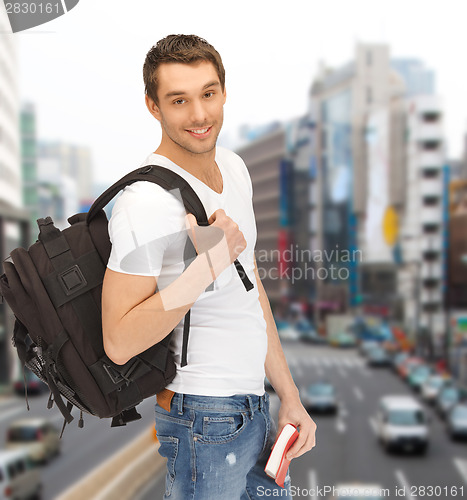 Image of travelling student with backpack and book