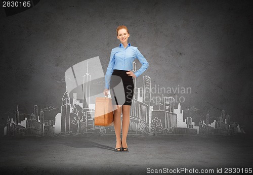 Image of smiling businesswoman with suitcase
