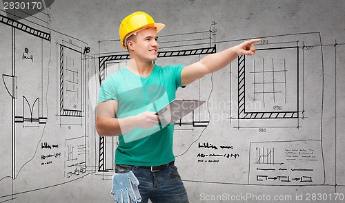 Image of smiling man in helmet with clipboard